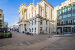 a man walking a dog in front of a building at Brighton central stylish stays. Walk to the beach. in Brighton & Hove