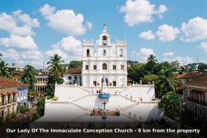 a large white building with a clock tower at Townhouse Oak Calangute in Goa