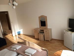 a living room with a bed and a mirror at Penzión Kýčera in Oščadnica
