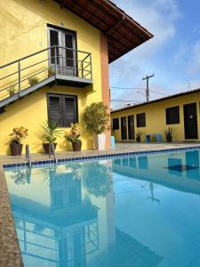 a house with a swimming pool in front of a building at Hotel Sambaquis in São Luís
