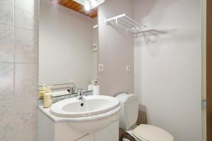 a white bathroom with a toilet and a sink at Chambres Escale Pontilabienne in Pont-lʼAbbé-dʼArnoult
