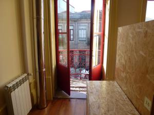 eine offene Tür, die zu einem Zimmer mit Balkon führt in der Unterkunft Canvas Atelier Hostel in Porto