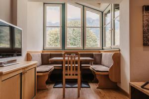 a dining room with a table and chairs and windows at Landhaus Rohrmoser in Werfenweng