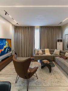 a living room with a couch and a tv at M&N Apartment in Ikate