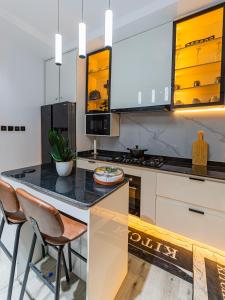 a kitchen with a counter and stools in it at M&N Apartment in Ikate