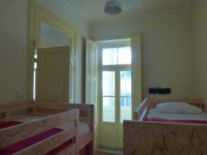 een slaapkamer met 2 bedden, een bad en een raam bij Canvas Atelier Hostel in Porto