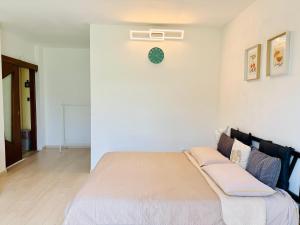 a bedroom with a bed with a clock on the wall at Casa Buda 2BR Apartment-Lakes Malpensa MXP 24h Check-in Parking in Sesto Calende