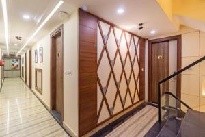 a corridor in a building with wooden doors and stairs at Treebo Premium Paarth Grand with Pure Veg Restaurant in Haridwār