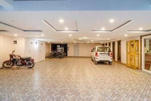 a garage with a van and a motorcycle parked in it at Treebo Premium Paarth Grand with Pure Veg Restaurant in Haridwār +29 photos