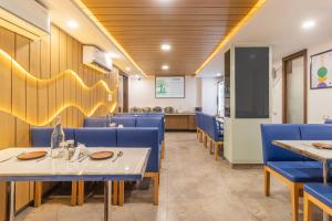 a dining room with blue chairs and tables at Treebo Premium Paarth Grand with Pure Veg Restaurant in Haridwār