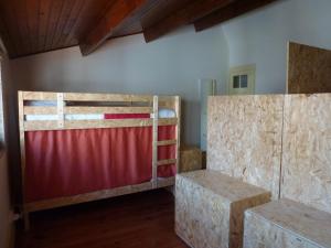 een kamer met 2 stapelbedden en een rood hek bij Canvas Atelier Hostel in Porto