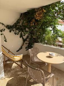 a patio with two chairs and a table and a tree at La Maison De Ville - Piscine & SPA in Sète