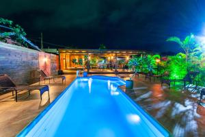 a swimming pool at night with tables and chairs at Pousada Gauleses - Refugio de Charme na Praia do Rosa by La Vem Férias in Praia do Rosa