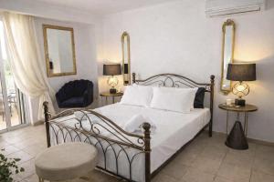a bedroom with a bed and a chair and a mirror at Sun Suite in Sitia