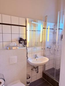 a bathroom with a sink and a shower and a toilet at Hotel Excellent in Lübeck +31 photos