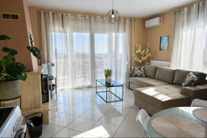 a living room with a couch and a table at Maison De La Mer in Paleo Tsifliki