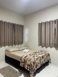 a bedroom with a bed with a blanket on it at POUSADA ORTEGA in Bodoquena