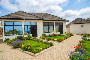 a house with a garden with flowers in front of it at Venue 360 Hotel in Freetown