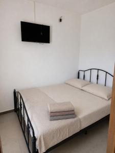 a bedroom with a bed with a flat screen tv on the wall at Apartmani Kasteljan 5,Stara Novalja in Stara Novalja
