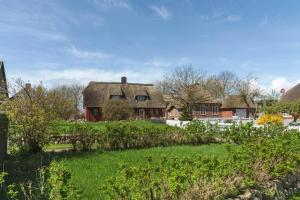 an old house with a thatched roof in a yard at Haus Bei Der Kirche in Oland