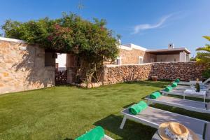a row of tables and chairs in a yard at New! Villa Can Marsoch in Santa Eularia des Riu