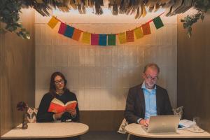 a man and a woman sitting at tables with a laptop at The Usual Brussels in Brussels