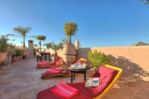 eine Terrasse mit Stühlen und einem Tisch in der Wüste in der Unterkunft Dar Lalla F'dila in Marrakesch