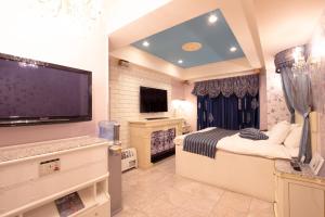 a bedroom with a large flat screen tv and a bed at Canon Himeji Higashi (Adult Only) in Himeji