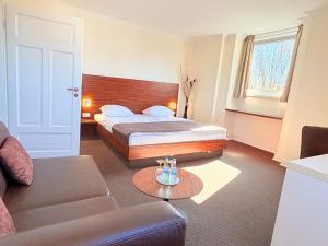 a hotel room with a bed and a couch at Hotel Excellent in Lübeck