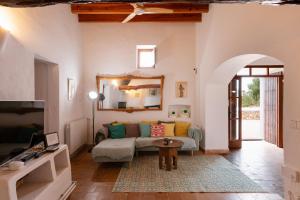 a living room with a couch and a mirror at New! Villa Can Marsoch in Santa Eularia des Riu