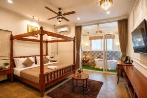 a bedroom with a canopy bed and a tub at Dimaru Boutique Hotel in Calangute +48 photos