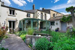 a house with a garden in front of it at Chambres Escale Pontilabienne in Pont-lʼAbbé-dʼArnoult
