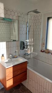 a bathroom with a sink and a tub and a mirror at maison caroline bairon in Le Chesne