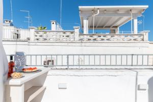 a white balcony with a plate of food on it at Ostuni Luxury Stay - 2 Jacuzzi in Ostuni