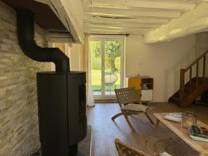 a fireplace in a living room with a table and chairs at Le Clos du Avre - Maison calme & jardin verdoyant in Breux-sur-Avre +22 photos