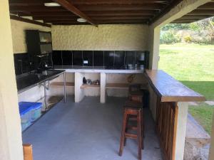 an outdoor kitchen with a counter and a stool at Finca la Albania in Circasia