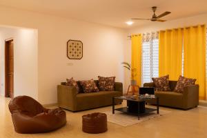 a living room with two couches and a table at LiveAway Bengaluru, HSR by PACK in Bangalore +28 photos
