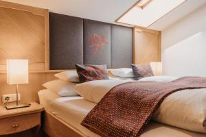 a bedroom with two beds with pillows and a window at Landhaus Rohrmoser in Werfenweng