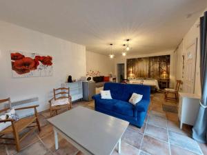 a living room with a blue couch and a table at Le Clos des 4 Saisons in La Rochepot
