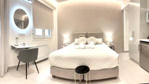 a bedroom with a large white bed and a kitchen at The Corfu Urban Stays in Ágios Rókkos
