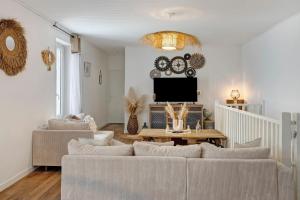a living room with two couches and a tv at Le Cocon d'Eymet village in Eymet