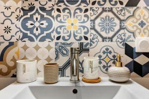 a bathroom sink with three cups on top of it at Le Cocon d'Eymet village in Eymet +19 photos