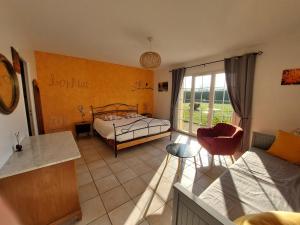a room with a bedroom with a bed and a table at Le Clos des 4 Saisons in La Rochepot