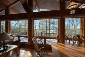 a dining room with a table and chairs and windows at Stack's Back Bay Retreat in Minocqua