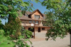 a large brick house with a courtyard in front of it at Podkowa in Police