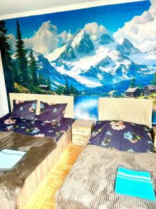 a bedroom with two beds and a mountain mural at Budget Home in Kutaisi