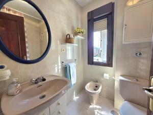 a bathroom with a sink and a toilet and a mirror at Apartamento Candela 6904 in Noja