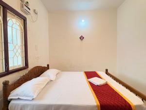 a bedroom with a bed in a room with a window at Neon Villa in Pondicherry