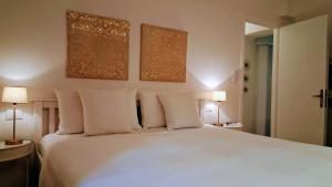 a bedroom with a bed with white sheets and pillows at Casa Bruna in Levanto