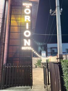 a hotel sign is lit up behind a gate at Orion Hotel in Almaty